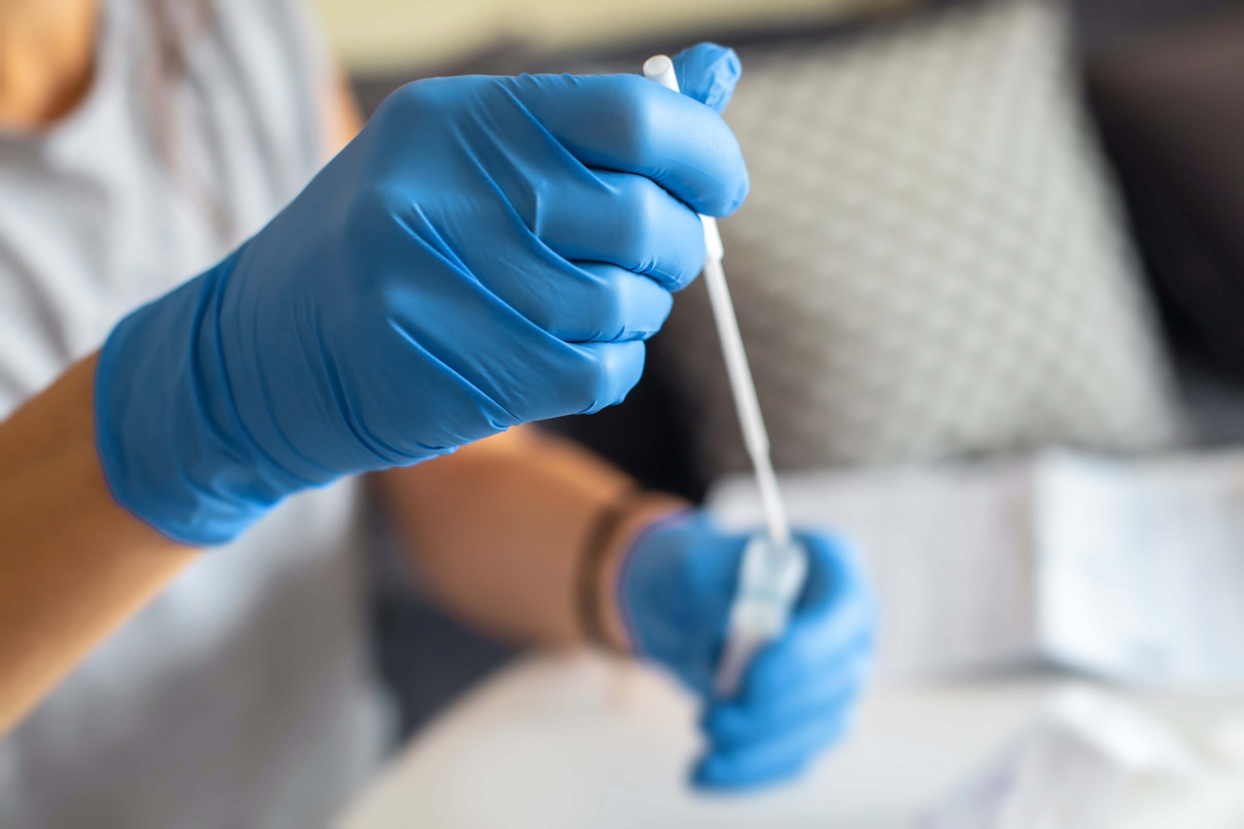 Lab worker deposits swab into test tube